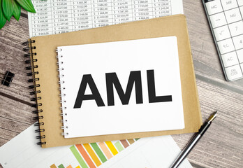 Text AML Anti-Money Laundering on notepad and pen on wooden background