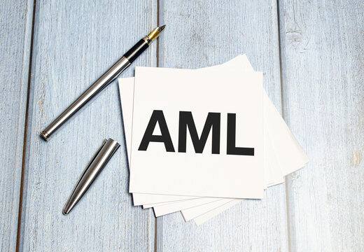 On the wooden desk is a sheet of paper with the inscription - AML Anti-Money Laundering