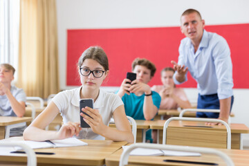 Students using smartphones in university class