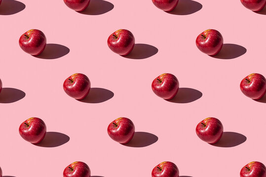 seamless pattern of a photo of a fresh ripe red apple on a pink background