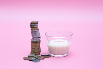 small glass of milk with coins around