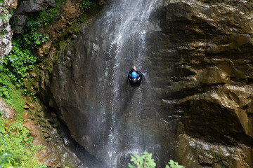 alpinist climbing down a waterfall - obrazy, fototapety, plakaty