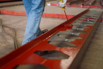 Worker painting steel beam in construction site