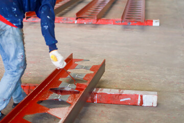 Worker painting steel beam in construction site