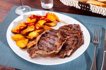 Tasty homemade baked beef fillet served with fried potato wedges and ketchup