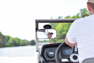 Middle aged man driving boat on a lake