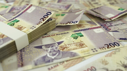 close up of 200 Namibian dollar notes spread on table. 3d rendering on money scattered on surface