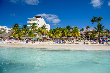 People sunbathing on the white sand beach with umbrellas, bungalow bar and cocos palms, turquoise caribbean sea, Isla Mujeres island, Caribbean Sea, Cancun, Yucatan, Mexico