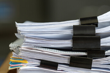 Stack of papers files documents achieves with clips on work in office