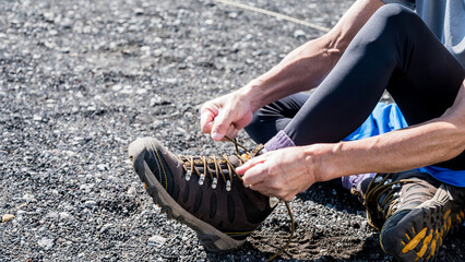 登山靴の靴紐を閉める男性　トレッキングシューズ
