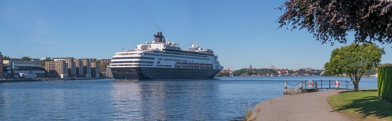 Fototapeta na wymiar A cruise ship arriving between the apartment islands Kvarnholmen and Djurgården, a sunny summer day in Stockholm