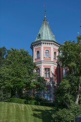 Fototapeta na wymiar A mansion pink tower in the island Djurgården, a sunny summer day in Stockholm Sweden 2022-07-12