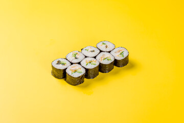 roll with cucumber and eel on yellow background