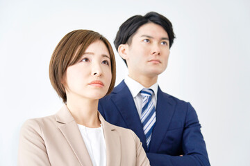 腕組みするビジネスウーマンとビジネスマンのポートレート　白背景