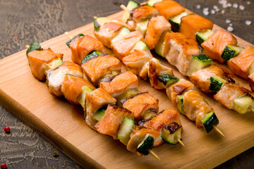 salmon fillet cooked on the grill with grilled zuccini on board, canapes