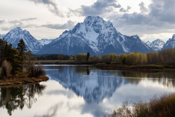Naklejka premium River surrounded by Trees and Mountains in American Landscape. Snake River, Oxbow Bend. Spring Season. Grand Teton National Park. Wyoming, United States. Nature Background.