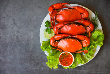 fresh crab on white plate and seafood sauce, crab cooking food boiled or steamed crab red in the restaurant, seafood plate with herbs spices rosemary lemon lime salad lettuce vegetable