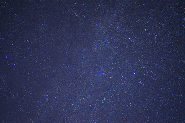 A fragment of the night starry sky with bright stars and several tracks.