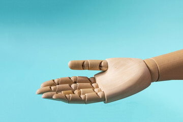 A wooden hand with an open palm, on a blue background of the space mine.
