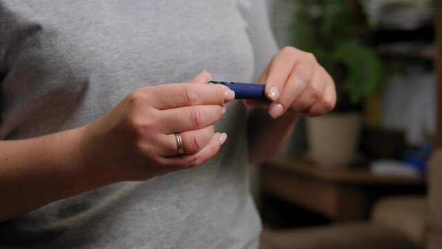 Close-up of an unrecognizable diabetic woman dialing the correct dose of insulin on a syringe pen before an injection. The concept of medicine and treatment of type 1 diabetes.