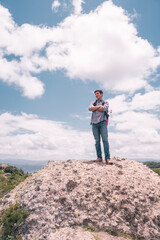 Fototapeta na wymiar Latin college student on a hill with his arms crossed looking at the sky in Jinotega Nicaragua