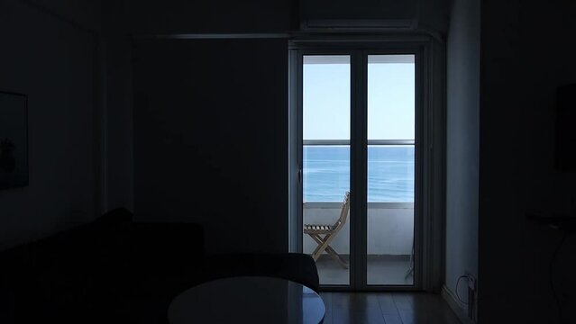 Cozy place on the balcony with a sea background. Dark room. Silhouette light