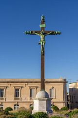 Cityscape view of ancient bronze calvary and beautiful stone buildings on place Giral, in the historic center of Montpellier, France, on a bright blue sky summer morning