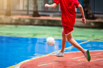 futsal player run to shoot ball.  Youth futsal league.