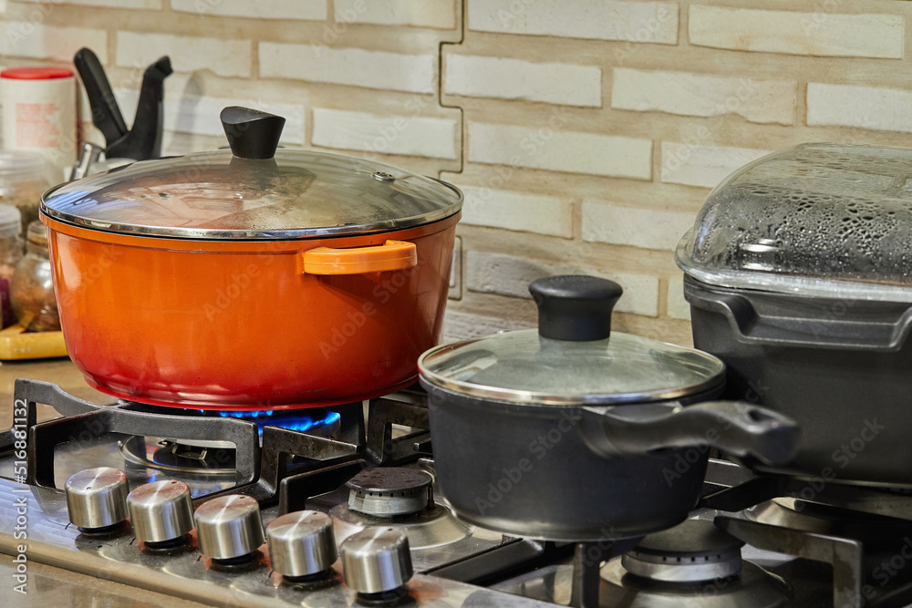 Poster Preparing food in frying pan and casseroles on the gas stove in the kitchen. Home cooking concept