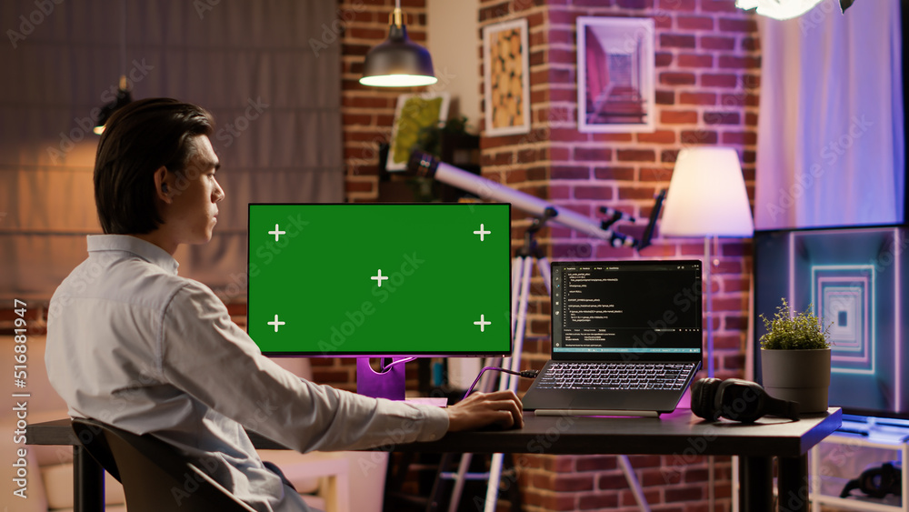 Poster office employee analyzing greenscreen on computer monitor at home desk. using blank chroma key templ