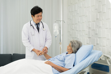 Obraz premium Doctor taking care elderly asian woman on bed at the hospital. People and health care concept