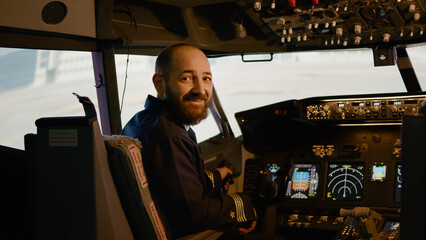 Portrait of airplane captain preparing to fly aircraft in cockpit, using control panel dashboard...
