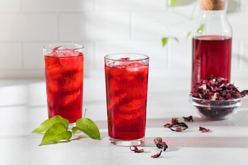 A refreshing drink made of dried hibiscus leaves and ice in a glass.