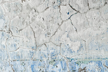 Old and dirty crumbling wall with peeling paint and cracks texture. Grunge interior background closeup