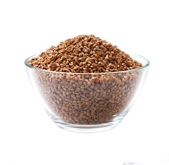 organic buckwheat in a clear glass bowl isolated on white background.