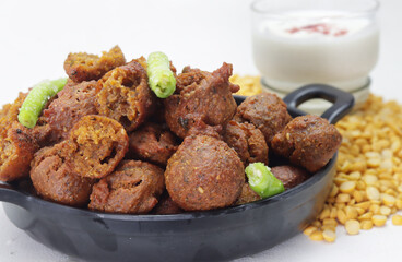 Delicious  crispy and crunchy Indian deepfried snacks Dal vada or dal pakoda or moong dal vade or pakora or fritters with green chilly and chutney or curd.
