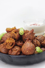 Delicious  crispy and crunchy Indian deepfried snacks Dal vada or dal pakoda or moong dal vade or pakora or fritters with green chilly and chutney or curd.