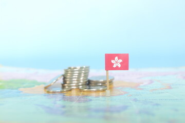Selective focus of Hong Kong flag in blurry world map with coins. Hong Kong economy and wealth...