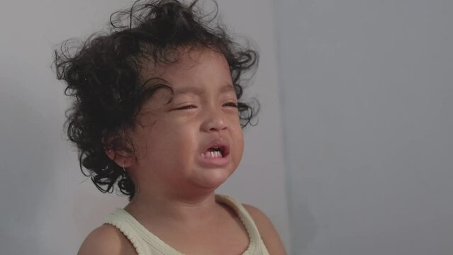 little asian baby girl with curly hair tantrum, crying loudly. slow motion video