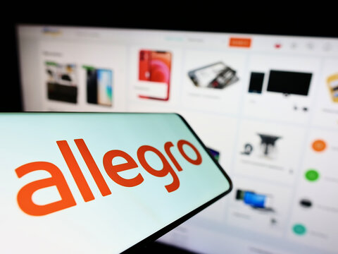 Stuttgart, Germany - 07-10-2022: Smartphone with logo of Polish e-commerce company Allegro.pl Sp. z o. o. on screen in front of website. Focus on center-left of phone display.