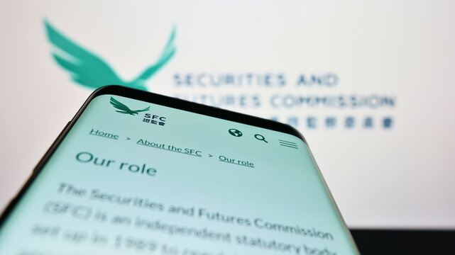 Stuttgart, Germany - 07-10-2022: Mobile phone with website of Hong Kong Securities and Futures Commission (SFC) on screen in front of logo. Focus on top-left of phone display.