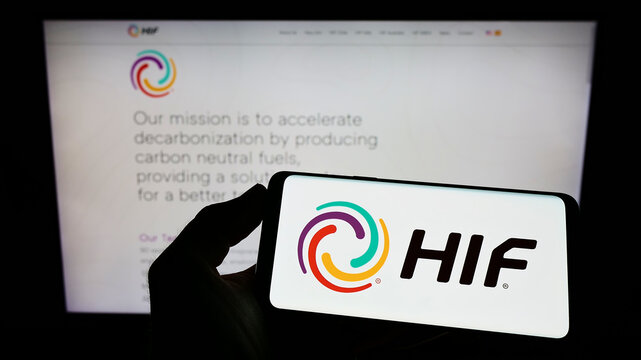 Stuttgart, Germany - 07-10-2022: Person holding mobile phone with logo of Chilean e-fuel company HIF Global on screen in front of business web page. Focus on phone display.