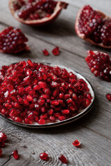 Broken pomegranate. Peeled pomegranate seeds. Pomegranate close-up on a wooden table.