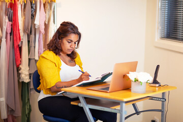businesswoman working at small desk at home