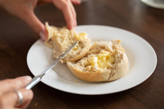 buttering a homemade bun or a white plate