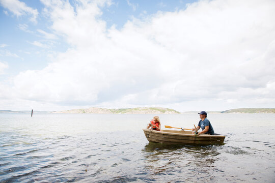 Father and daughter in rowboat on sea