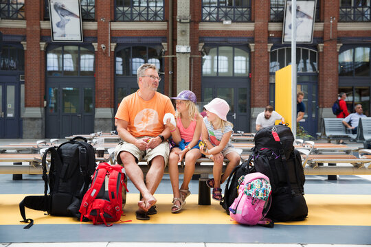 Family sitting on bench at train station