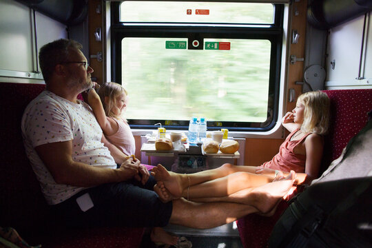 Family sitting by window on train