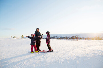 Family standing in snow while skiing