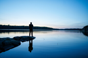 Silhouette of man by sea at sunset in Bjorno Sweden